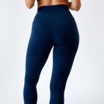 Back view of a model wearing high waist cropped yoga pants in Navy Blue, studio shot on white background.