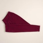 Flat lay of seamless black leggings pocket leggings in burgundy, neatly folded on a neutral surface.