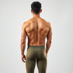 Back view of a model wearing olive green yoga pants men, showcasing fit and cut, studio shot on white background.