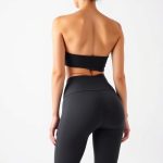 A model wearing black yoga pants women in Charcoal, showcasing fit from behind on white studio background.