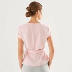 Back view of a pastel pink bamboo wrap top on a model, showcasing its eco-conscious fit and cut.