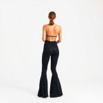 Back view of a model wearing the best flare leggings from yoga website in Black.