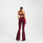 Back view of a model wearing burgundy cotton yoga pants flared leggings on a white background.