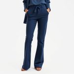 Navy Blue flared pants outfit, conscious clothing on white studio background.
