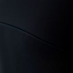 Close-up of the flares black yoga top fabric, showing its texture and quality stitching.