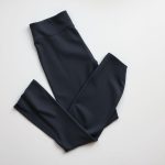 Flat lay of charcoal high waisted yoga pants women flare style, neatly folded on neutral surface.