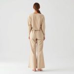 Back view of a model wearing organic cotton yoga pants flare lounge pants in Beige.