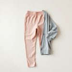 Heather grey organic cotton cardigan and pink yoga pants folded flat lay.