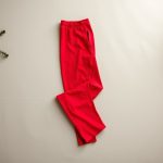 Flat lay of red wide leg yoga pants folded neatly on a neutral surface, wide leg yoga pants Australia.