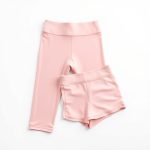 Pastel pink yoga pants and yoga short on white background, hyperrealistic e-commerce photo, 8k quality.