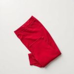 Red flare black yoga pants yoga neatly folded on a neutral surface, top-down view.